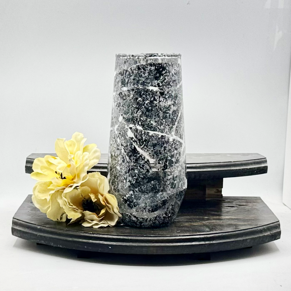 BrookeLynn's Home Shadowed Swirl glass vase with black and white marbled stone finish next to yellow flowers.